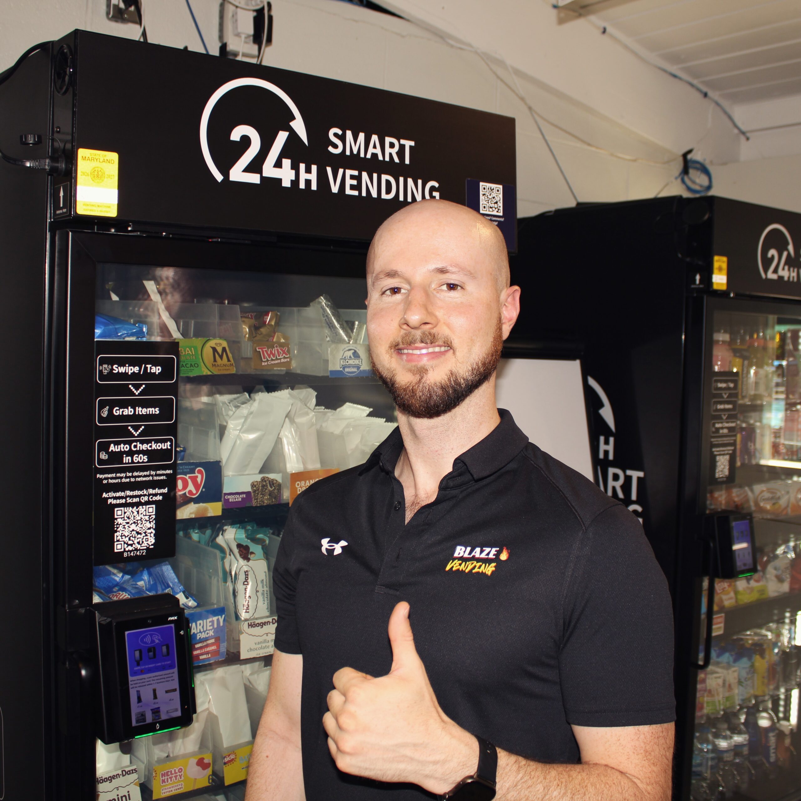 Kyle Kotler, founder of Blaze Vending, standing in front of a 24h smart cooler